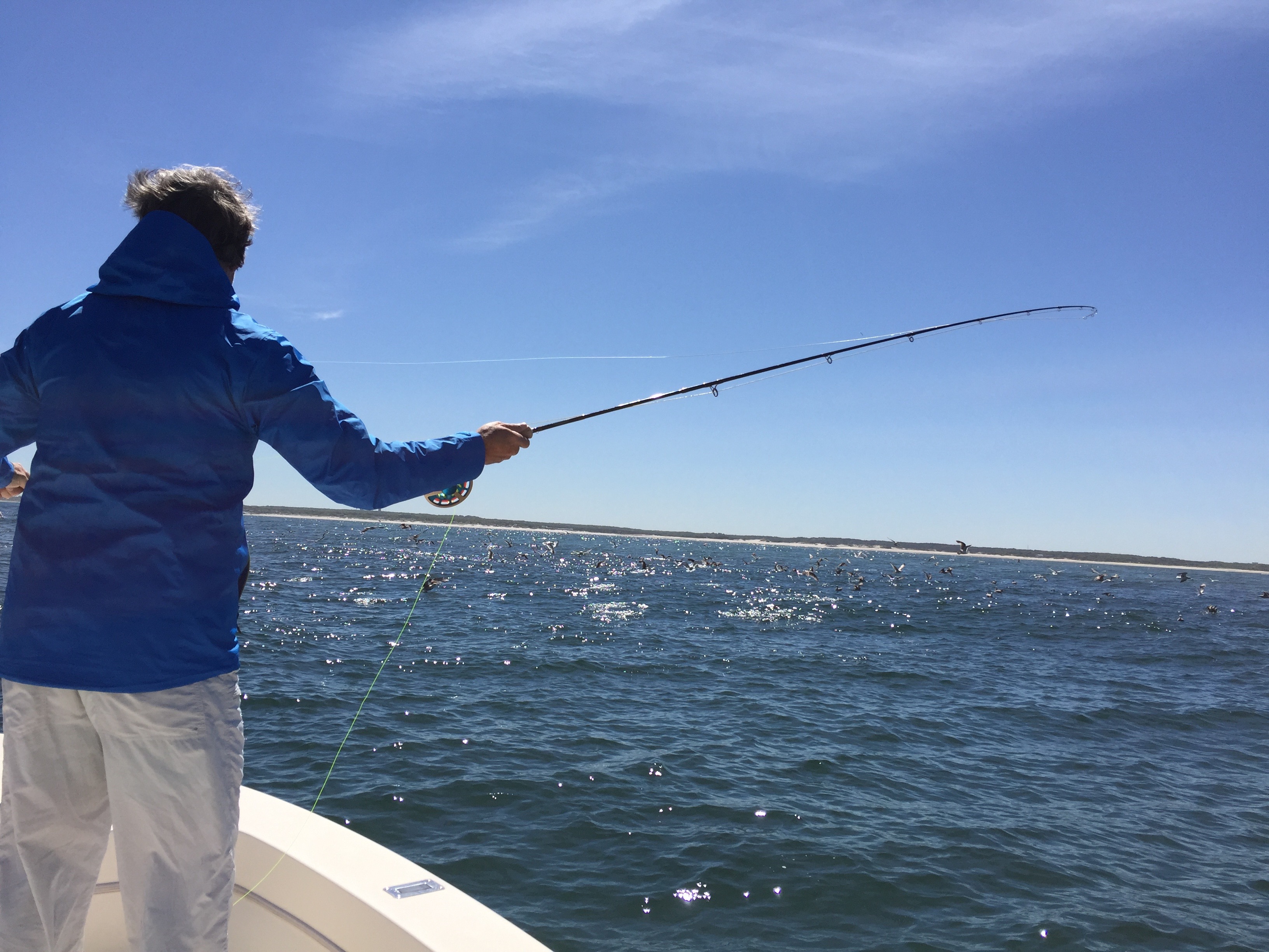 Over the shoulder picture of man casting a fly rod