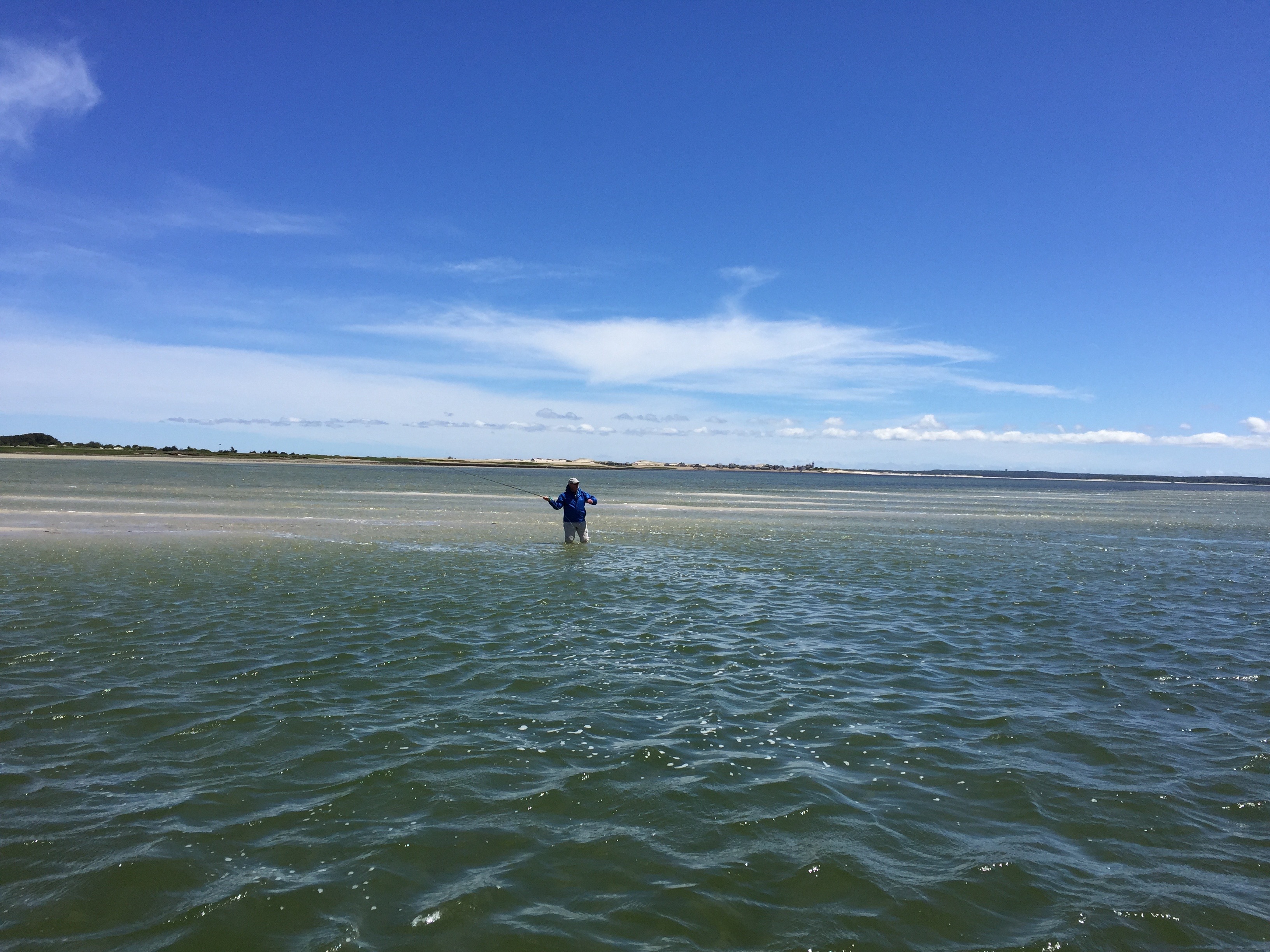 Man on a sand flat fly fishing