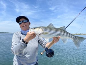 Capt. Avery Revere with a striped bass and a fly rod