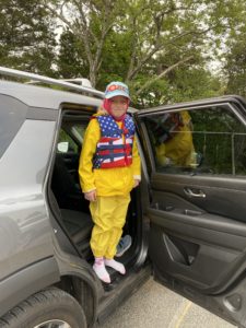 Young girl in a red white and blue life jacket and yellow rain gear
